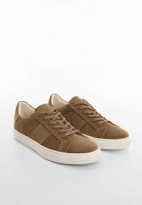 Baskets en daim marron avec une texture lisse, dotées de lacets plats, d'un bout rond et d'une semelle en caoutchouc blanche contrastante. Design minimaliste avec des accents latéraux.