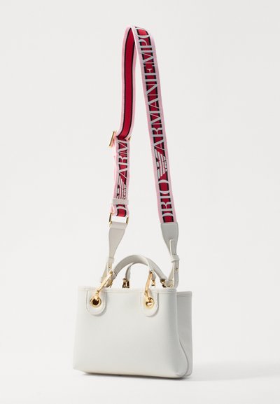 White leather handbag with a structured shape, gold hardware, and thick strap featuring pink and red colors with bold text.