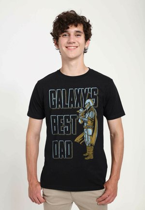 Black T-shirt featuring a graphic of a character in armor, with the text "GALAXY'S BEST DAD" in bold, colored letters.