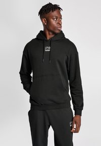 Svart huvtröja i bomullsblandning, med en framficka, dragsko på huvan och logotyp på bröstet. Kombinera med matching sweatpants.