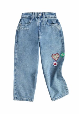 Lyseblå denim bukser med "Kindness" broderet nær lommen og hjerte- og cirkulære patches på højre ben.