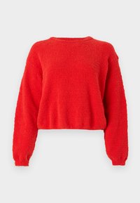 Pull rouge, court, à manches longues. Fabriqué en tissu texturé et duveteux. Encolure ronde simple sans fermetures visibles.