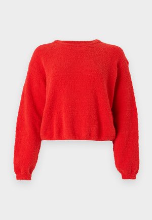 Rød, kortermet genser med lange ermer. Laget av fluffy teksturert stoff. Enkel rund hals med ingen synlige lukninger.