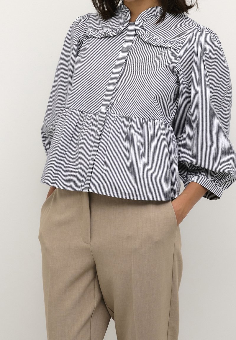 Gestreepte katoenen blouse met een ronde kraag, pofmouwen en plooien in de taille, gecombineerd met op maat gemaakte beige broek.