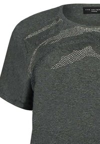 Šedé tričko s krátkým rukávem vyrobené z měkkého materiálu, s texturovaným designem a stříbrnými cvočky uspořádanými do vlnitých vzorů na přední straně.