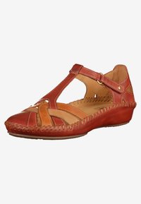 Sandalo in pelle rossa con punta chiusa e lati aperti, caratterizzato da intricati intagli e dettagli in contrasto color tan. Cuciture lungo la suola.