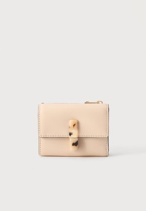 Beige leren portemonnee met een tortoise-shell-achtige sluiting en zichtbare stiksels, tegen een effen lichte achtergrond.