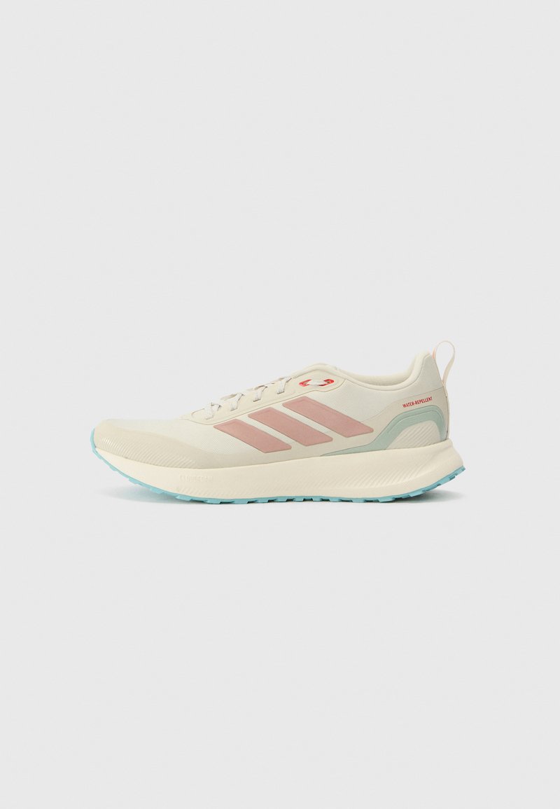 Beige sportssko med pink accenter og tre sidelister. Har en rund tå, tekstureret sål og letvægt, vandafvisende materiale.