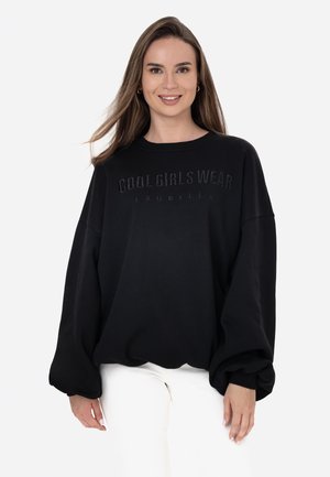 Black sweatshirt featuring the embossed text "COOL GIRLS WEAR LAURELLA," with oversized sleeves and a relaxed fit. Soft, smooth texture.