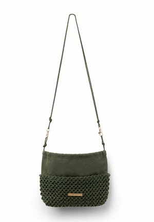 Bolso bandolera verde oscuro con mitad inferior tejida, mitad superior lisa, correa ajustable y pequeña placa rectangular dorada de la marca.