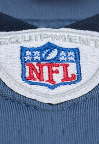 NFL-Logo-Patch mit blauer, roter und weißer Stickerei. Das Patch hat die Form eines Schildes mit einem Football und Sternen darüber.