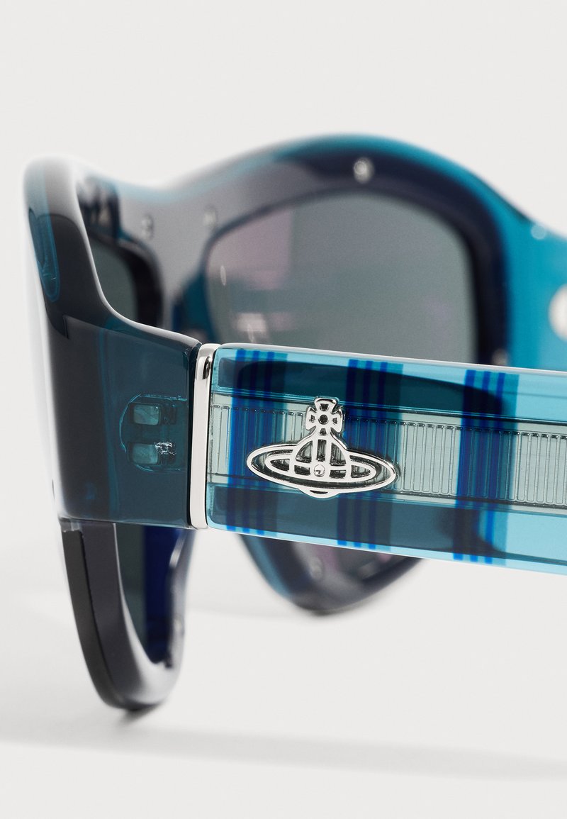 Gros plan du bras translucide bleu de lunettes de soleil avec logo orb argenté Vivienne Westwood et verres teintés foncés.