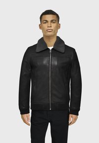 Chaqueta de cuero negra con un suave collar gris, cremallera frontal, puños acanalados y dobladillo. Textura suave y diseño ajustado, estilizada para mantener el calor.
