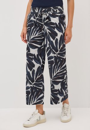 Pantalons amples en tissu à motifs présentant des feuilles sombres sur un fond clair, avec une taille élastique et un détail à cordon de serrage.