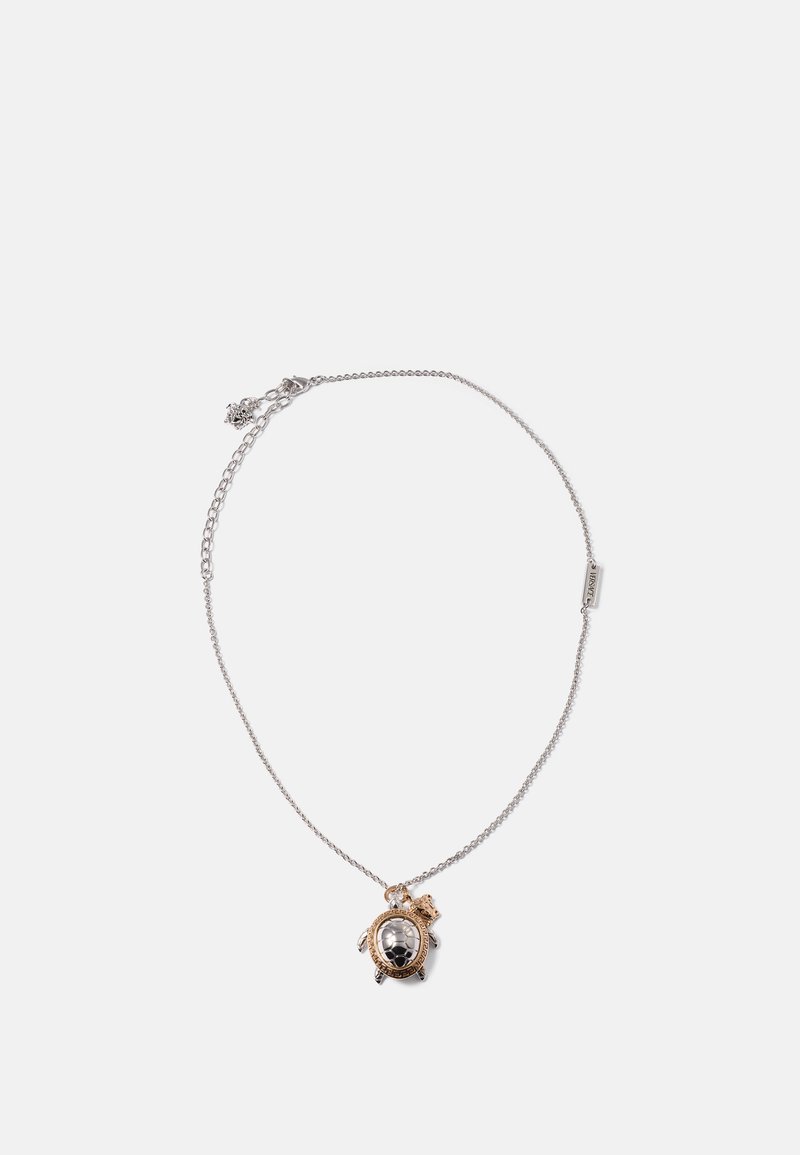 Colar de corrente prateada com um pendente de tartaruga apresentando uma concha polida em prata e detalhes em dourado, pernas detalhadas e uma superfície texturizada.