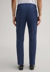 Marineblaue Hose aus strukturiertem Stoff mit aufgesetzten Taschen mit Knopfverschluss und taillierter Passform. Glatte Verarbeitung, gerade Beine.