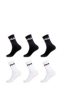 Chaussettes en coton noir et blanc avec logo. Trois paires : deux noires avec un logo coloré au niveau du poignet, et une blanche avec un logo marine au niveau du poignet.