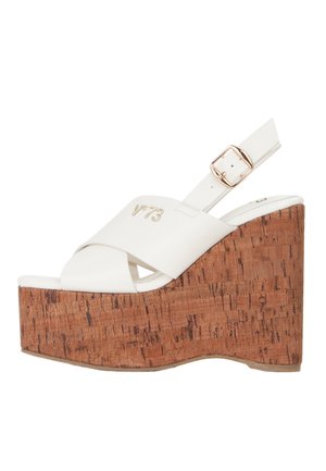 Sandalo con zeppa in pelle bianca con platform in sughero, cinturini incrociati, fibbia dorata e logo "v73" sul cinturino superiore.
