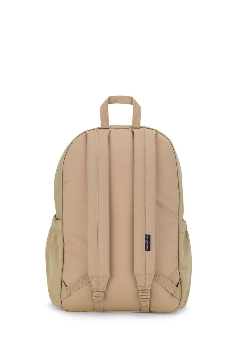 Sac à dos beige de forme arrondie, avec un dos et des bretelles rembourrés, deux poches latérales, et une poignée sur le dessus pour un transport facile.