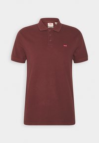 Camisa de polo burdeos hecha de algodón, con una tapeta de tres botones y un pequeño logotipo rojo de Levi's en el lado izquierdo del pecho. Mangas cortas.