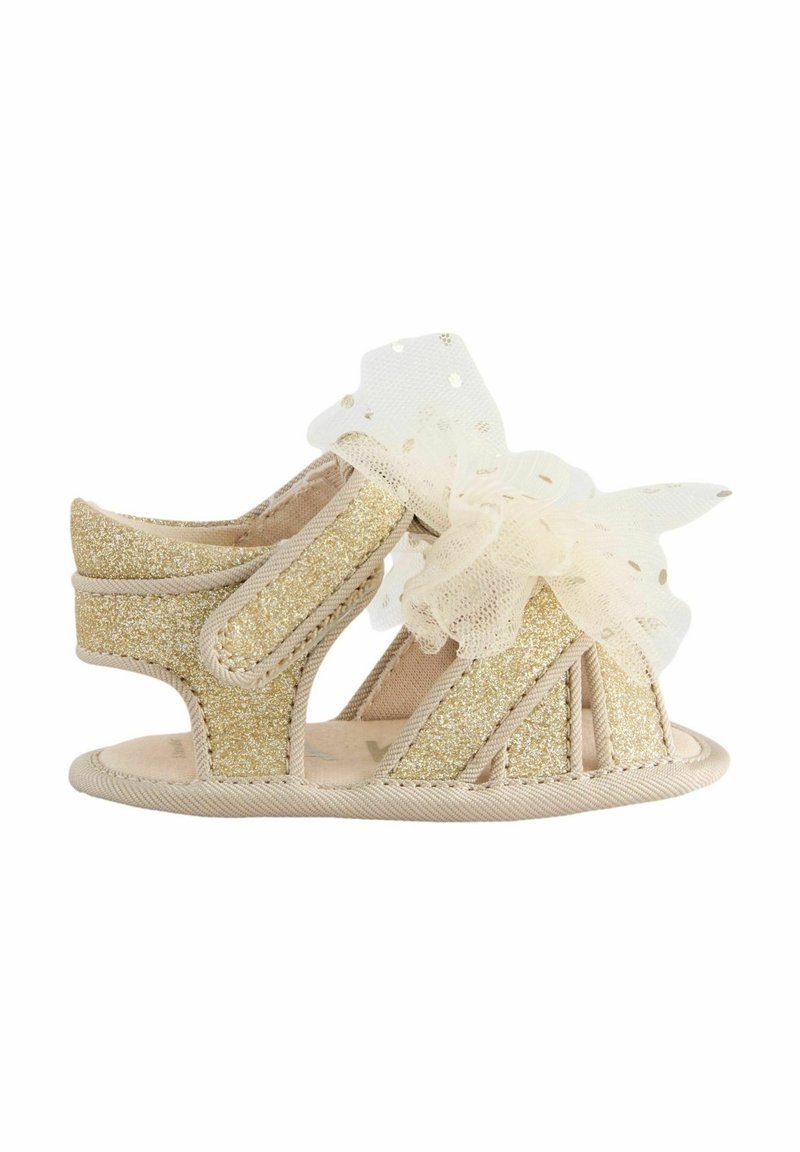 Sandale enfant dorée scintillante avec bord beige, orteil ouvert, et nœud crème transparent avec pois dorés sur le dessus.