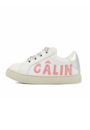 Baskets blanches avec le texte brodé en rose "CÂLIN", capuchon de talon argenté, lacets gris, semelle en caoutchouc texturé, et tige en cuir lisse.