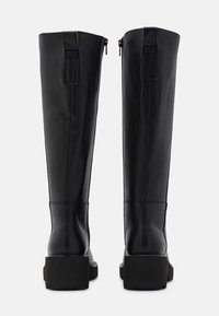 Black leather knee-high boots with a sleek design, square heels, side zippers, and minimal stitching details on the back.