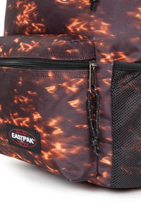 Eastpak-Rucksack mit einem dunklen lila und orangefarbenen Flammenmuster, strukturiertem Stoff, schwarzen Mesh-Elementen und einem Reißverschluss.