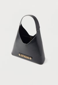 Sac à main en cuir noir en forme de trapèze avec une seule bandoulière, une couture blanche et une plaque logo dorée "LOVE MOSCHINO" à l'avant.