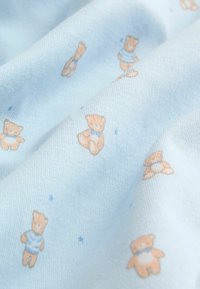 Hele sinine puuvillakangas pehmea tekstuuriga, millel on korduv muster erinevates asendites karude ning siniste aktsentidega.