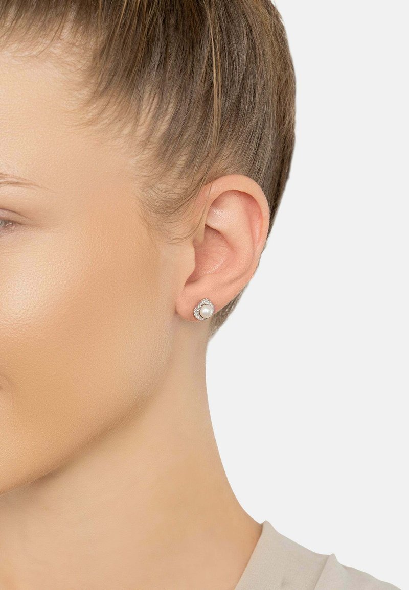 Round pearl stud earrings with a halo of small clear stones, featuring a silver-tone setting. The design is simple and elegant.