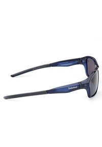 Gafas de sol polarizadas Timberland en plástico azul, con un diseño elegante, lentes oscuros y patillas grises con detalle de logo.