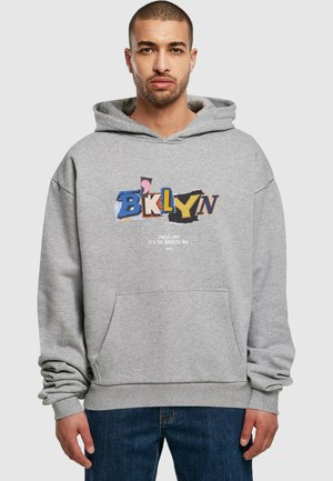 Gray hoodie with a front pocket, featuring a colorful "BKLYN" graphic and text "Spread Love It's the Brooklyn Way" below. Soft material.