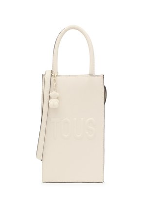 Bolso de mano texturizado en blanco con el logo "TOUS" en relieve, asas cortas, correa desmontable y un pequeño colgante en forma de oso adjunto.