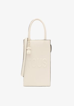 Bolso de mano texturizado en blanco con el logo "TOUS" en relieve, asas cortas, correa desmontable y un pequeño colgante en forma de oso adjunto.