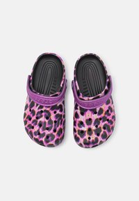 Purple and black leopard print clogs with a textured sole, an adjustable strap, and multiple ventilation holes for breathability.