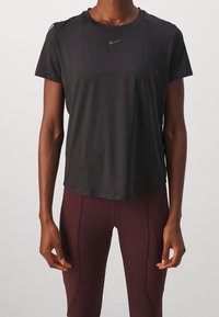 Czarny sportowy t-shirt Nike z krótkim rękawem o gładkiej fakturze, z okrągłym dekoltem i małym logo na piersi.