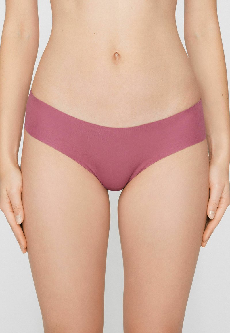 Ropa interior hipster sin costuras de color malva claro con textura suave y diseño de talle bajo, que cuenta con una cinturilla ancha y detalles mínimos de costura.