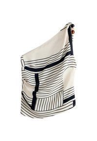 Top crème à une épaule en tissu avec motifs géométriques et rayés noirs et perles décoratives sur la bretelle.