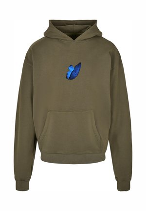 Olivno zelena kapuca z sprednjim žepom in vezenjem modrega metulja na prsih. Narejena iz mehkega blaga, z sproščenim krojem in kapuco s vrvico.