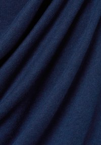 Marineblauwe gebreide stof met een zachte textuur, die subtiele variaties en een soepele uitstraling toont, gevouwen om de val te benadrukken.