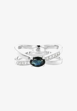 Silver crossover ring featuring an oval dark gemstone at the center, flanked by small clear stones along one band. Smooth, polished finish.
