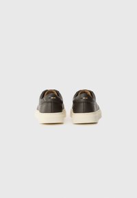 Barna bőr sneaker, textúrált felülettel, krémszínű gumitalppal és alacsony top kialakítással, két kis díszcsíkkal.