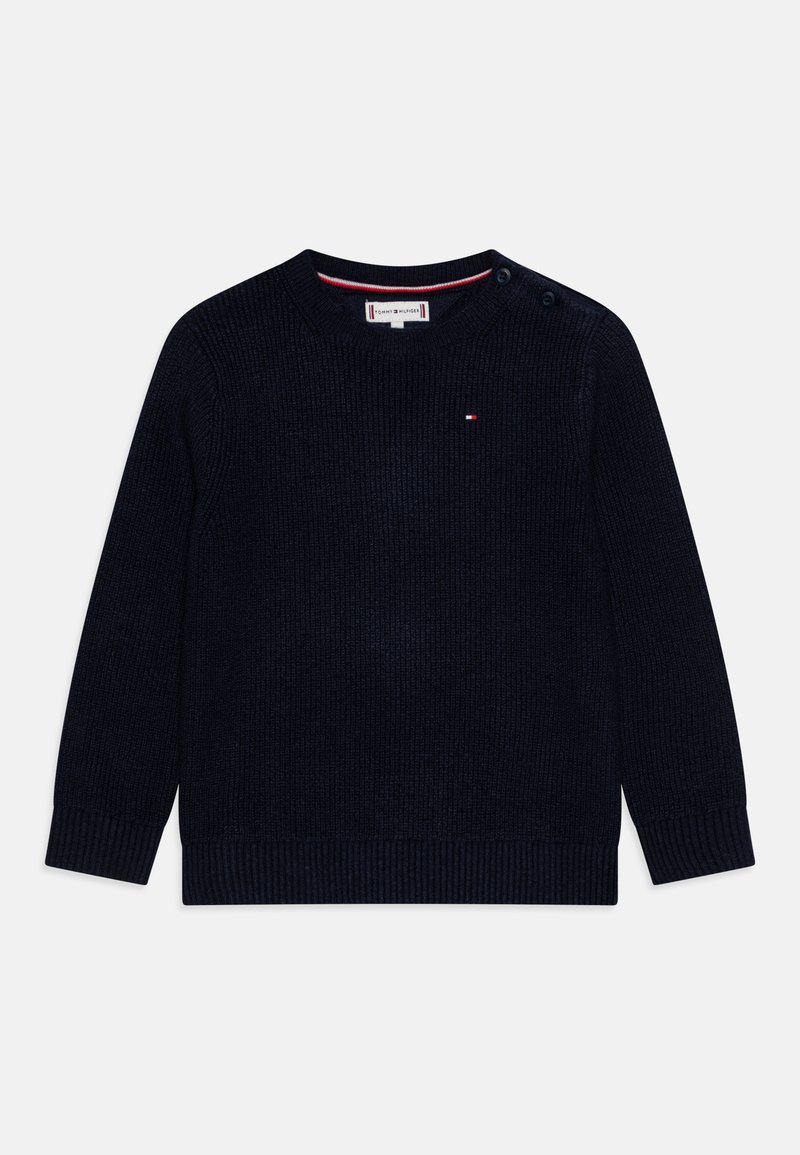 Pull en maille bleu marine avec texture côtelée, col rond et deux boutons à l'épaule. Présente un petit logo sur la poitrine.