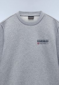 Sudadera gris hecha de tela suave, con cuello redondo, puños de canalé y un logotipo bordado en azul en el pecho con un acento de bandera noruega.