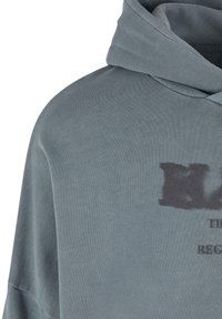 Grey cotton hoodie with a relaxed fit, featuring a hood and a faded graphic print on the front. Soft texture and solid color throughout.
