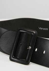 Cintura in pelle nera con finitura texturizzata, fibbia rettangolare e più fori per la regolazione. Presenta un logo del brand sul lato interno.