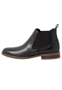 Černé kožené chelsea boty s texturovaným povrchem, elastickými bočními panely, malou smyčkou a hnědým „stacked“ podpatkem.