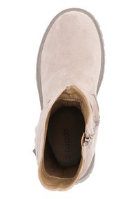 Bottine beige avec finition en daim, bout arrondi, fermeture éclaire sur le côté et semelle en caoutchouc texturé. L'intérieur est doublé d'un matériau doux.