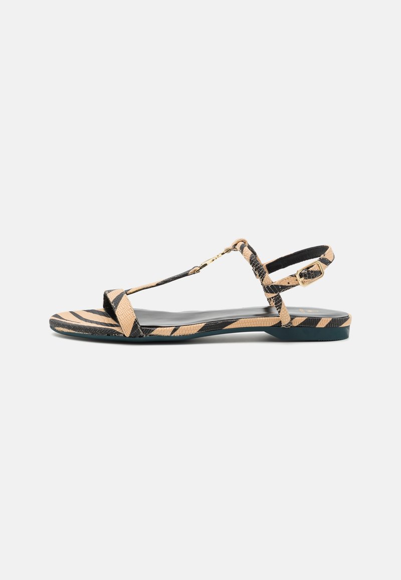 Svart og beige stripete flate sandaler med T-stroppdesign, teksturert kunstlær i slangeskinn, og justerbar ankelstropp med gullspenne.